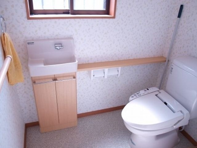 清潔な洋式トイレ トイレ 手すり付きで安心の清潔感のあふれるトイレ空間です。ゆったりと使いやすい設計になっており、快適さを重視しています。