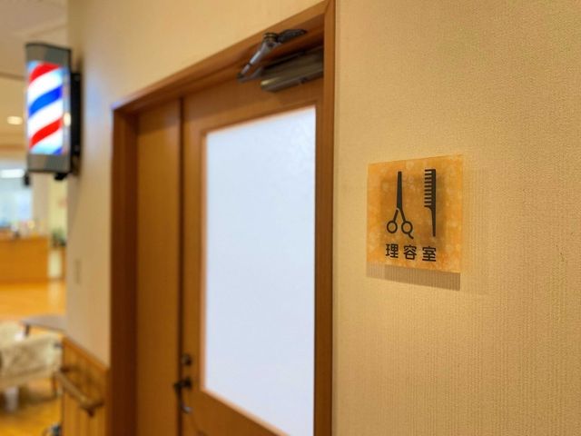 理美容室への入口 理美容室 理容室では明るい照明の下、快適なサービスが受けられます。髪のお手入れをしながらリフレッシュできる空間です。