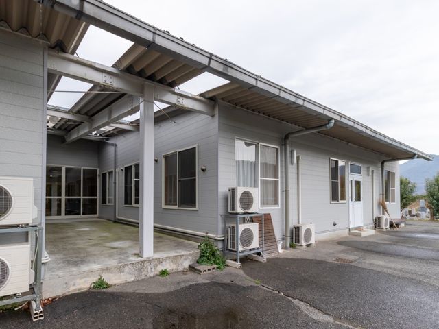 施設の外側の建物 外観 明るく清潔感のある外壁が心地良い印象を与えます。通気性もよく、自然の風を感じながら勤務ができる環境です。