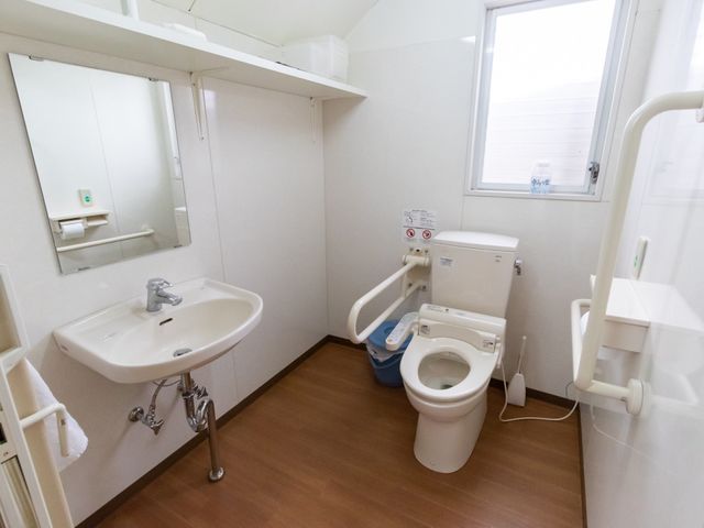 清潔なトイレ空間 トイレ 手すり付きで安全性を考慮した清潔なトイレスペースです。利用者の自立支援と快適性を重視しています。