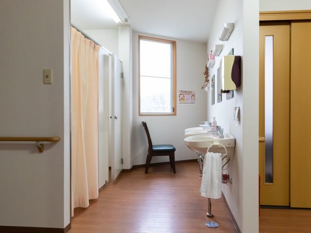 明るい廊下と洗面所 洗面台 手すり付きで安全に配慮された廊下です。設備の充実した洗面所があり、日々の生活に便利さを提供します。