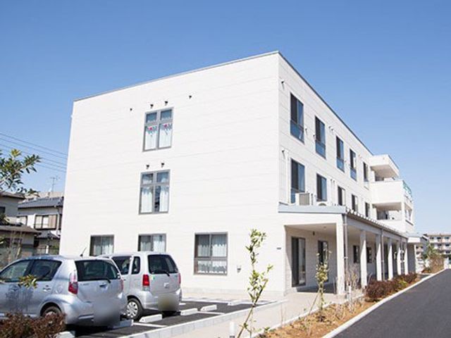 白い外壁の建物外観 外観 落ち着いた住宅街にある明るく広々とした施設です。ゆったりとした時間を過ごせる環境が整っております。