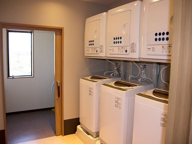 洗濯機が並ぶ洗濯室 洗濯室 清潔感のあふれる洗濯室は、いつでもご利用いただけます。毎日の生活に便利な設備が整っており、安心して暮らせる環境です。