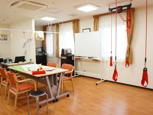 リハビリテーション室内部 共用スペース 広々とした機能訓練室で、日常生活をサポートする様々なトレーニング器具が整っています。明るい空間で、専門スタッフが皆様の健康維持をお手伝いします。