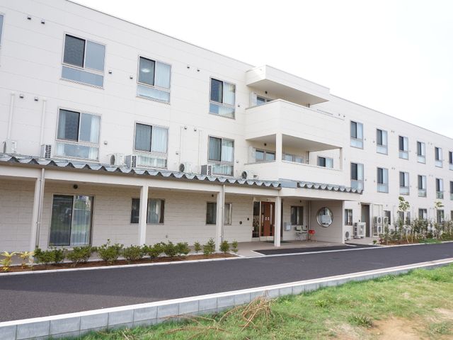白い建物の外観正面 外観 白を基調にした清潔感のあふれる建物の正面が映されています。広々としたエントランスは、訪れる方を温かく迎えます。