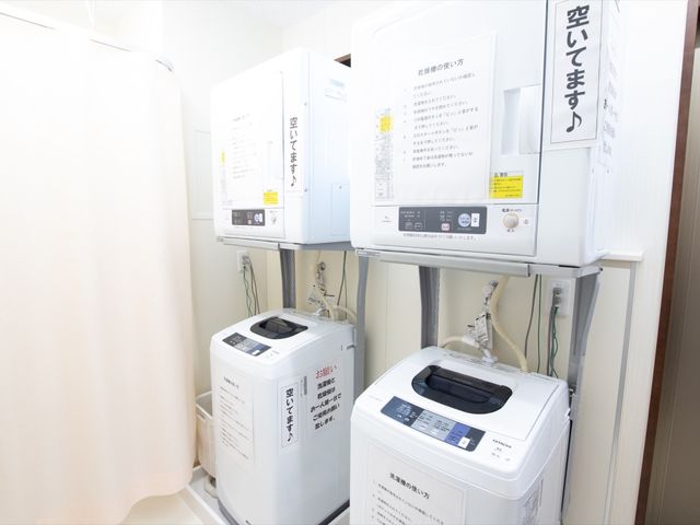 洗濯機の並ぶ設備スペース ランドリー 清潔に保たれた洗濯機の並びで、いつでも衣類のお手入れが可能です。快適な暮らしをサポートするため、設備は定期的にメンテナンスされています。