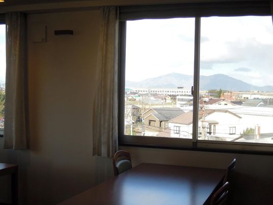 窓の側にテーブルと椅子が設置されている。窓からは、山や住宅街などが椅子に座った状態で見ることができる。