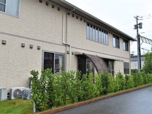 外観の建物と緑の様子 外観 穏やかな緑に囲まれた、落ち着いた雰囲気の外観です。清潔感があり、職場としての環境が整っています。