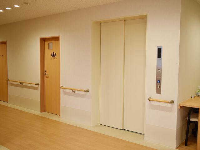 廊下とエレベーターのドア エレベーター 手すりが設置された広々とした廊下です。移動には安全で快適な環境が整っています。