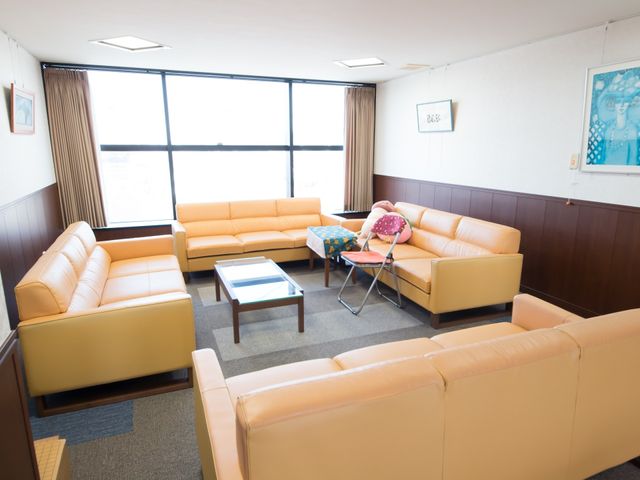 快適な居心地のラウンジ 談話室 ゆったりとしたソファが配置された休憩スペース。明るい窓辺でくつろぎながらコミュニケーションを楽しんでいる様子が伺えます。