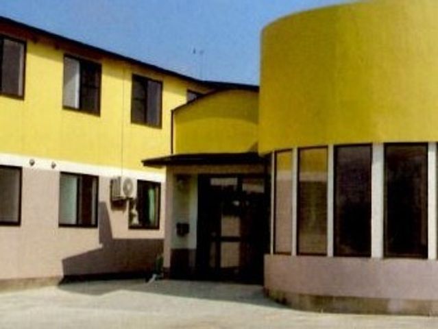 黄色の建物とエントランス 外観 明るいカラーのエントランスが迎える、ユニークな外観をした建物です。訪れる方々を温かく迎え入れるデザインが特徴です。