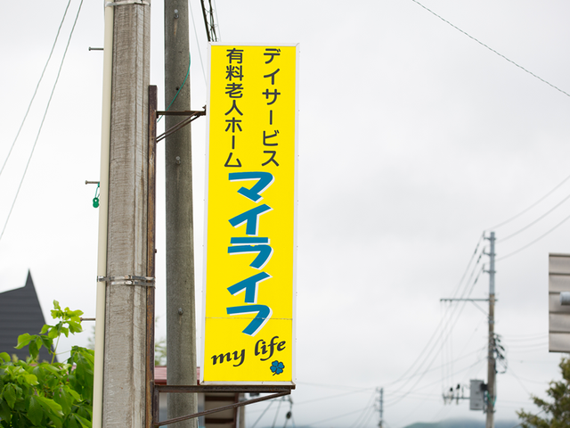 デイサービス看板外観 看板   黄色い看板に施設名が大きく表示されています。通り沿いで見つけやすく、働く場所の案内として分かりやすいです。
