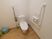 共用のトイレは広く作られた個室内に洗面台があり、便器のの背中側の壁に折りたためる金属製の手すりが設置されている。