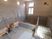 複数人で同時に使う浴場タイプの浴室。レンガ風のデザインがなされた壁には、丸い暖色系の照明が並んで配置されている。