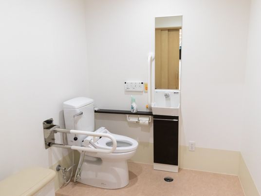 清潔感のある広々としたトイレである。手すりは可動式になっているので、車椅子ご利用の方も使用しやすい。