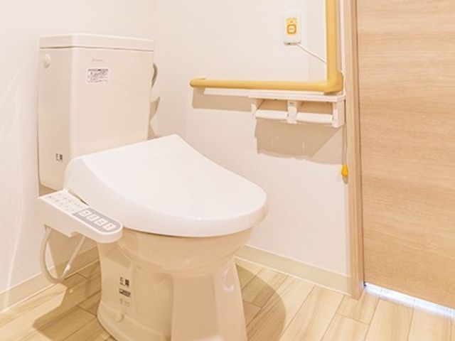 バリアフリー設計のトイレ トイレ 手すり付きで安全に配慮された清潔感あるトイレ空間です。利用者の自立支援と快適さを考慮した設計になっております。