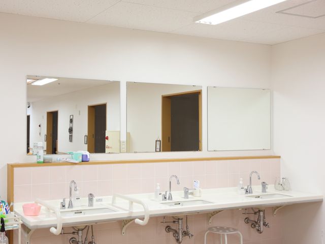 洗面台と鏡の設備 洗面台 清潔感のある洗面スペース、毎日の身だしなみに使いやすく整えられています。スタッフとして快適な環境でのサポートが可能です。