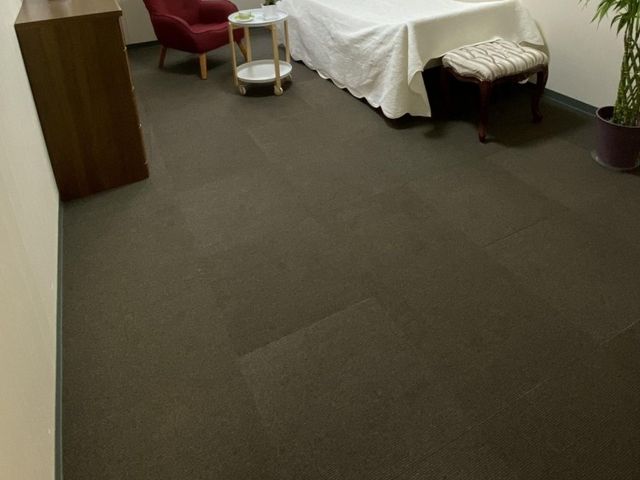 居室の床とベッド脇 居室   シンプルな居室で、ベッド脇に椅子とサイドテーブルが置かれています。床面が広く、移動しやすい印象です。