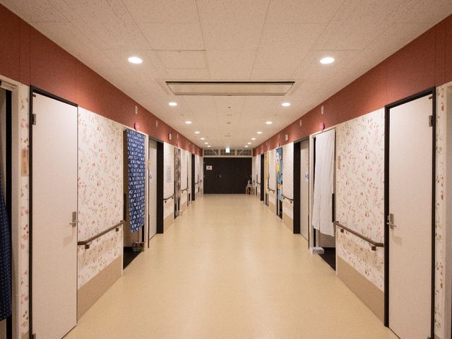 廊下の情緒あるデザイン 廊下 暖かみのある色合いで、落ち着いた雰囲気の廊下です。壁に掛けられた雅な柄のカーテンが、訪れる方を優雅に迎えます。