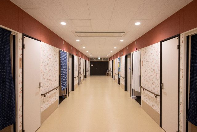 廊下の情緒あるデザイン 廊下 暖かみのある色合いで、落ち着いた雰囲気の廊下です。壁に掛けられた雅な柄のカーテンが、訪れる方を優雅に迎えます。