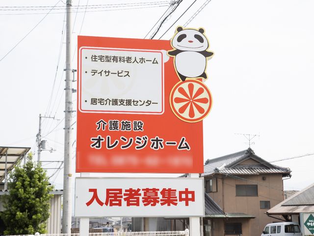 オレンジ色の施設看板 看板 目を引くオレンジ色の看板は、来訪者を温かくお迎えします。癒しのイラストが印象的で親しみやすい空間を予感させます。