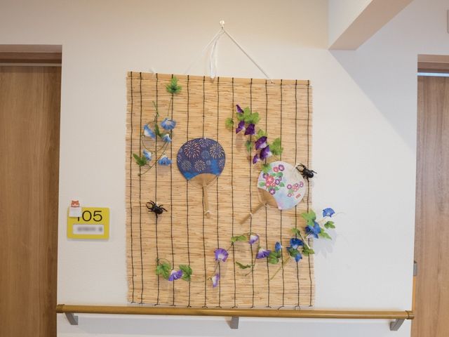 壁に飾られた手作り装飾 廊下 手作りの温もりが感じられる壁の装飾です。毎日の暮らしに彩りを添え、訪れる方々にも和やかな気持ちを提供します。