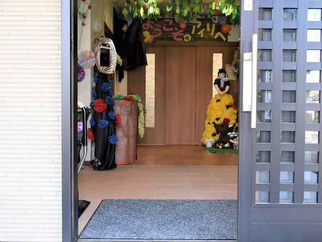 エントランスの装飾と人形 玄関 歓迎するあたたかい雰囲気のエントランスが印象的です。色彩豊かなデコレーションとキャラクターの人形が、訪れる方を優しく迎え入れます。