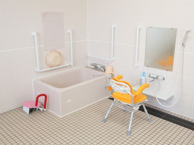 バリアフリー設計の浴室 浴室 安全に配慮された清潔感ある浴室です。手すりや椅子も整っており、利用する方の快適さを考えた設計になっています。