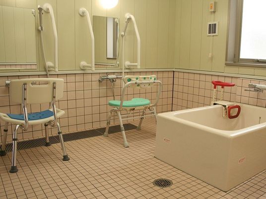 浴槽には高さを調節できる手すりが取り付けられており、立ち座りを安全に行うことができる。洗い場の上には照明がついている。