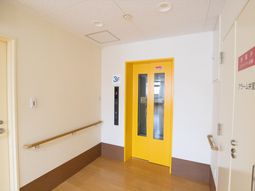 黄色いエレベーターの廊下