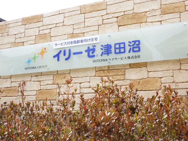 色とりどりの植物と看板 看板 温かみのある色を配した施設の看板が、親しみやすい雰囲気を醸し出しています。訪れる方々を心地よく迎える第一歩となります。