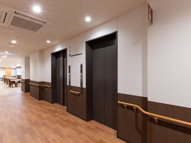 廊下とエレベーター エレベーター 明るく清潔な通路には、手すりが設けられていて安全に移動ができます。バリアフリー設計になっており、どなたでも快適にお過ごしいただける環境です。