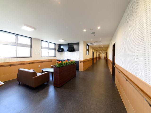 廊下の清潔な空間 休憩スペース 床から天井まできれいに保たれた廊下には、待合席が設けられ、日差しが差し込む心地よい場所です。このような環境で働くことができます。