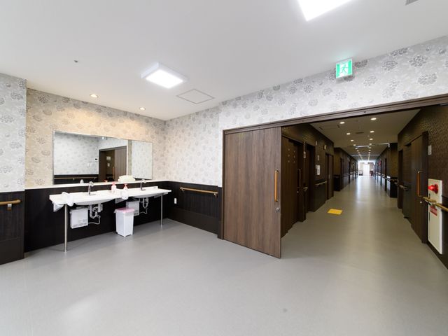 清潔感ある施設の洗面台 通路 広々とした清潔な洗面台が配された施設です。利用者の方が快適に過ごせるよう配慮された設計となっております。