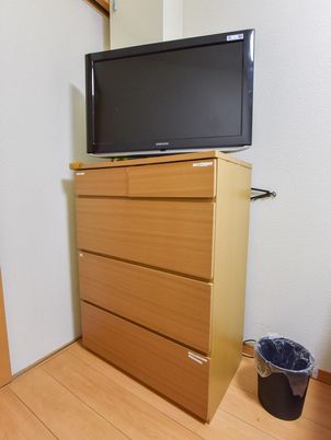 壁掛けテレビと木製タンス