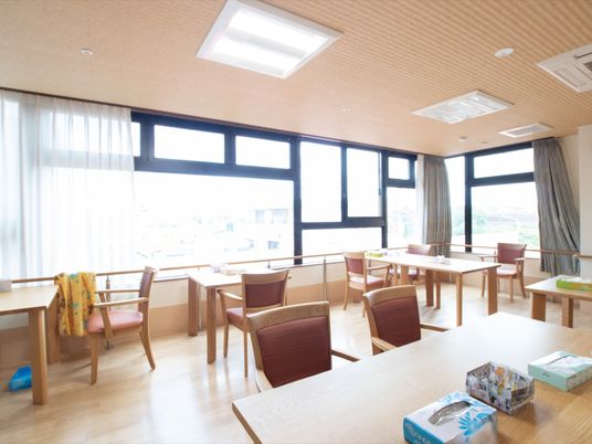 施設の写真 大きな窓から明るい日差しがたっぷりと射しこんでいる食堂である。２人掛けや４人掛けのダイニングテーブルが、ゆとりを持って配置されている。