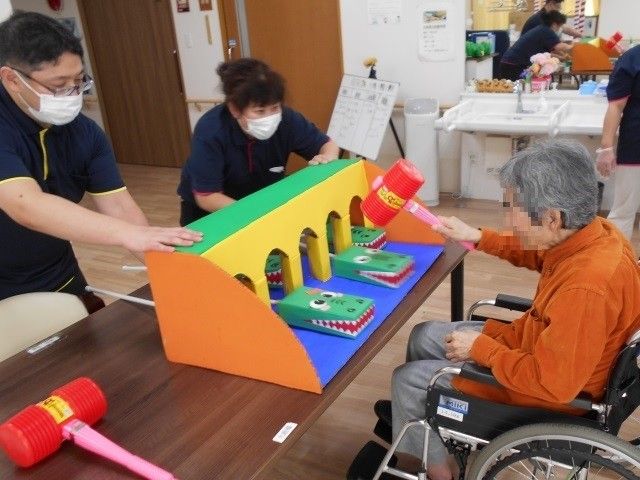 機能訓練の様子 機能訓練室 スタッフのサポートのもと、楽しみながら体を動かすトレーニングが行われています。車椅子に座る方も参加できる配慮がされています。