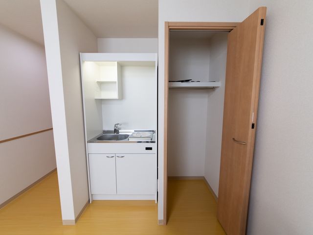 洋室の洗面台とクローゼット 居室 快適にご利用いただけるシンプルな洗面台と収納が備わった落ち着いた空間です。清潔感があり、日常生活に必要な機能を整えています。