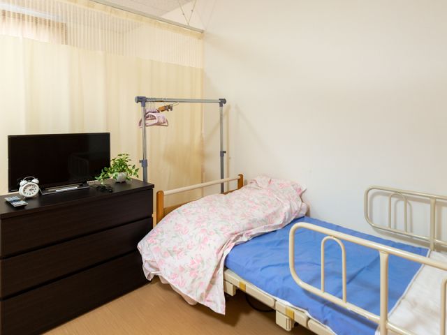 居室にベッドとテレビ 居室 整えられた居室には、必要な備品が揃っており、快適に過ごせる配慮がされています。日々の生活を大切にした空間です。