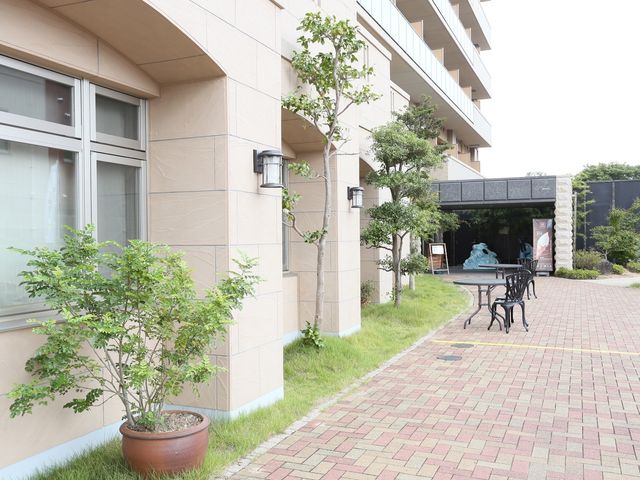 落ち着いた雰囲気のエントランス 外観 緑に囲まれた清潔なエントランスが、訪れる人を優しく迎え入れます。ゆったりとした休憩スペースも完備されており、開放的です。