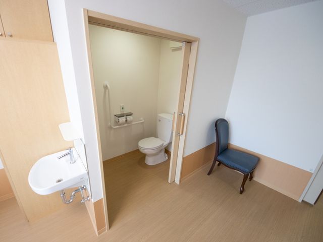 バリアフリーのトイレ空間 居室 広々としたバリアフリー設計の洗面・トイレスペースです。手すりが設置され、安全性にも配慮されています。