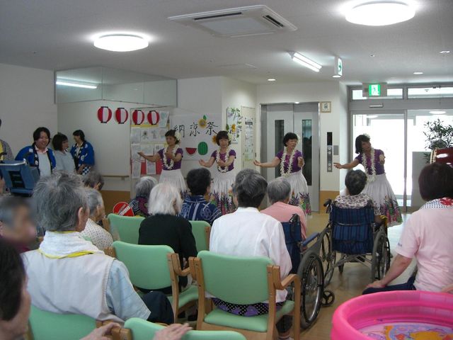 多目的室でのレクリエーション イベント ほほ笑みあふれる多目的室で、職員が楽しいレクリエーションを実施しており、利用者が笑顔で見守っています。