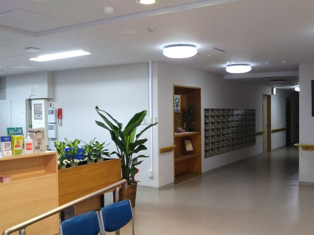 廊下と植物の和み空間 玄関ホール 清潔感のあふれる廊下は、緑の植物で彩られ癒しの空間を提供しています。ゆったりとした時間をこの場所で過ごせます。