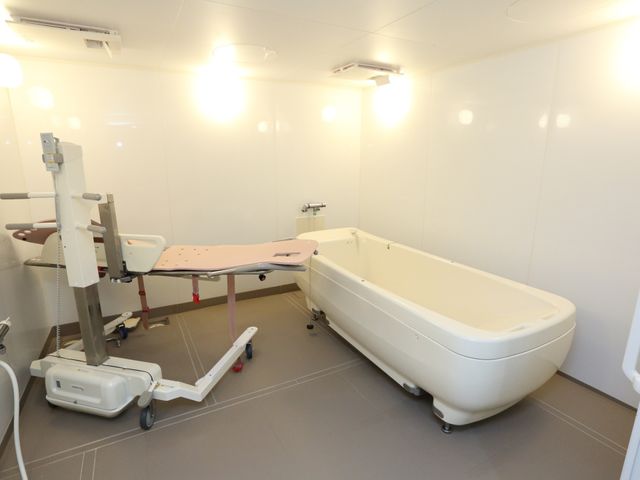 介護用浴室の設備 機械浴室 清潔感ある広々とした浴室は、リフト付きでゆったり入浴できる環境が整っています。安全に配慮された設計は、利用者様の心地よい時間を支えます。