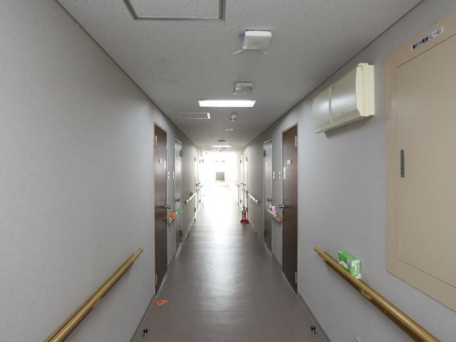 明るく清潔な廊下 廊下 手すりが設置された広々とした廊下です。壁面の案内表示も見やすく、安全に移動できる環境が整っております。
