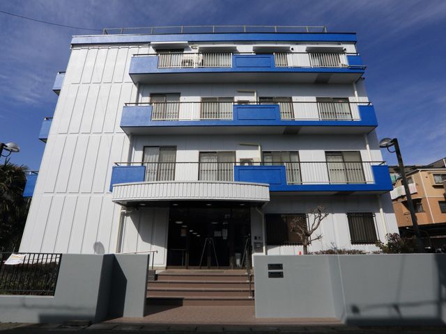 青いアクセントの建物外観 外観 青いラインが印象的な外観は、日当たりが良く、清潔感にあふれた環境を提供しています。お仕事をお探しの方に、心地よい勤務空間をご紹介いたします。