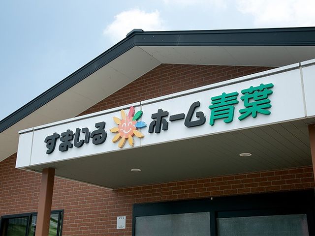 施設看板の外観 看板   建物の正面に施設名の看板が設置されています。来訪者に分かりやすい、落ち着いた外観です。