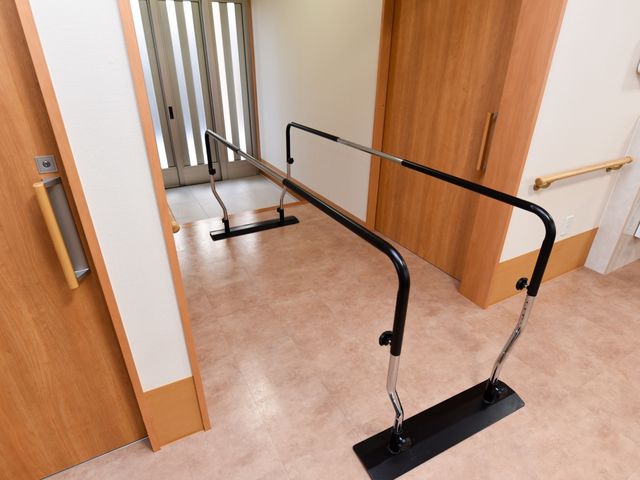 歩行訓練用の手すり設置廊下 歩行補助器 廊下に手すりが完備されたバリアフリー設計です。歩行訓練にも適しており、安全に配慮された環境を整えています。