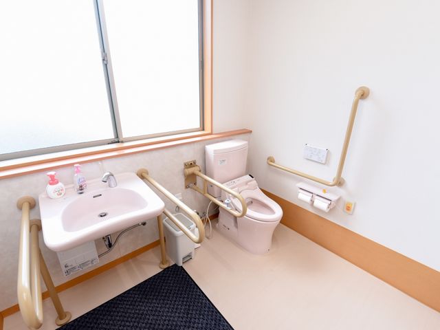 手すり付きの清潔なトイレ トイレ 安全に配慮された手すりが設置された清潔感のあるトイレです。利用者の快適な生活を支える設備が整っています。