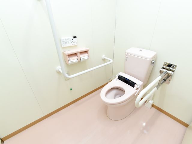 バリアフリートイレの一角 トイレ 手すり付き清潔なトイレは、ご利用者の安全を考慮した設計です。快適な日常生活を支えるための配慮が感じられます。